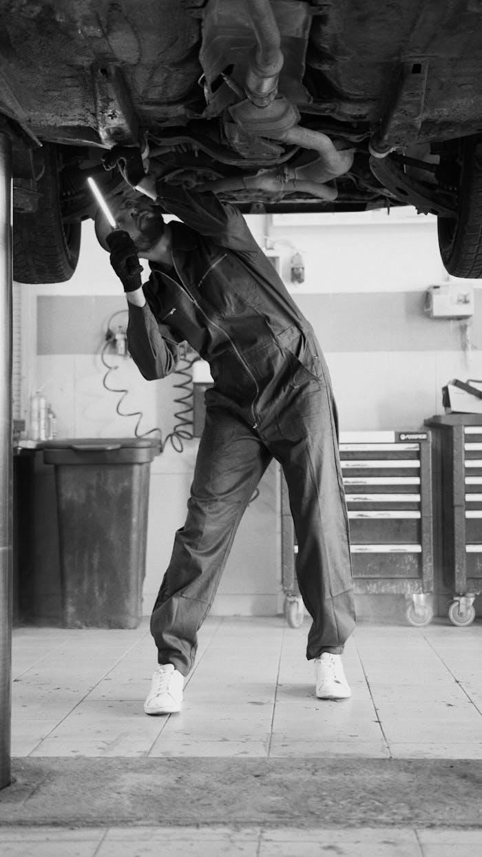 Services-02 A mechanic inspecting a vehicle in a workshop, highlighting automotive maintenance.