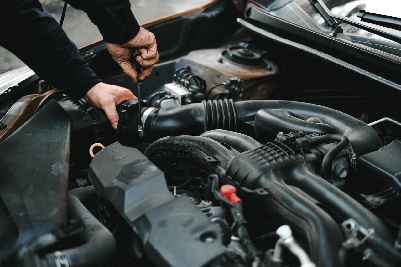 creative-03 Close-up of a mechanic working on a car engine. Ideal for auto repair themes.